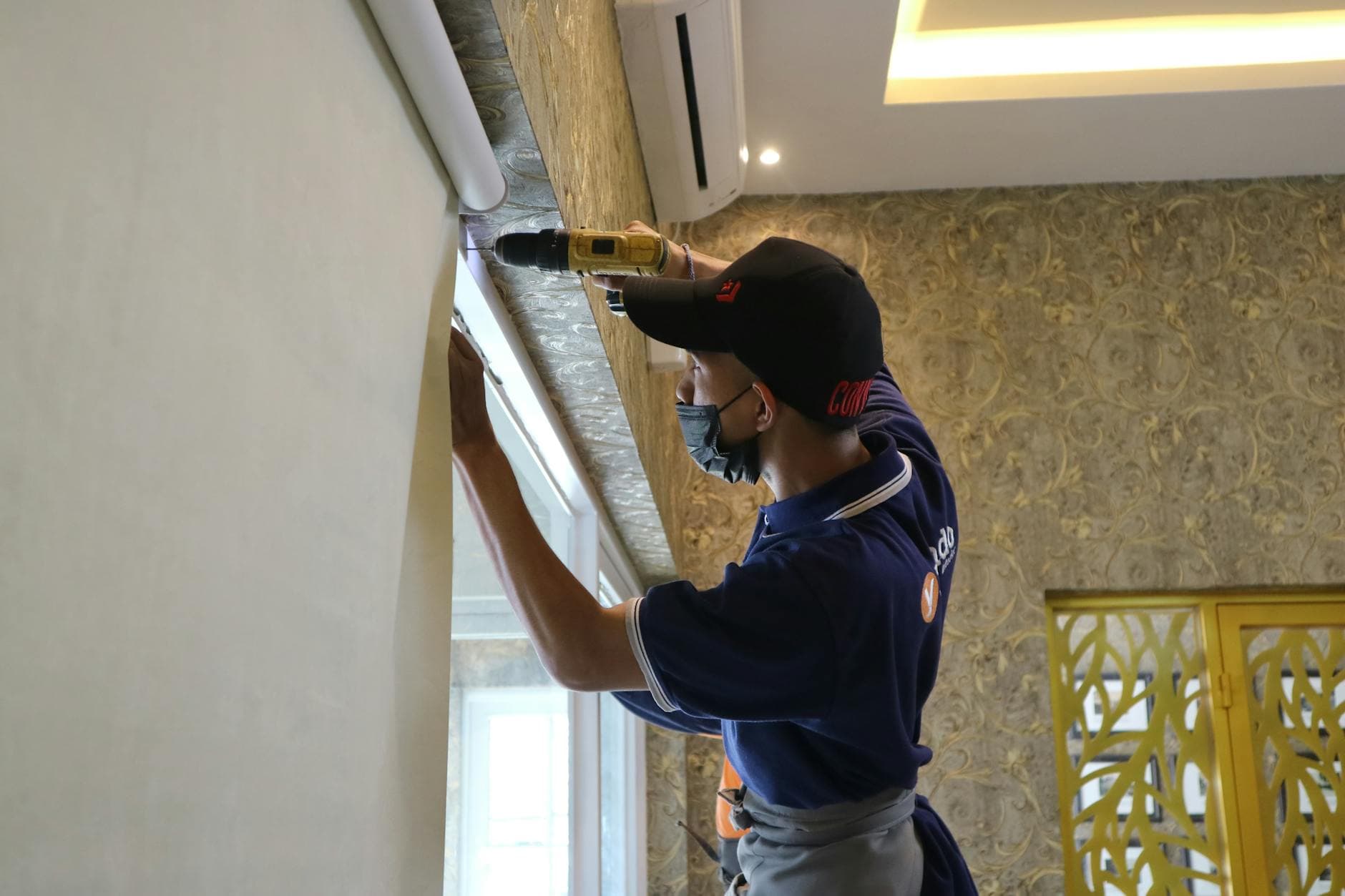Persona trabajando en la instalación de una persiana